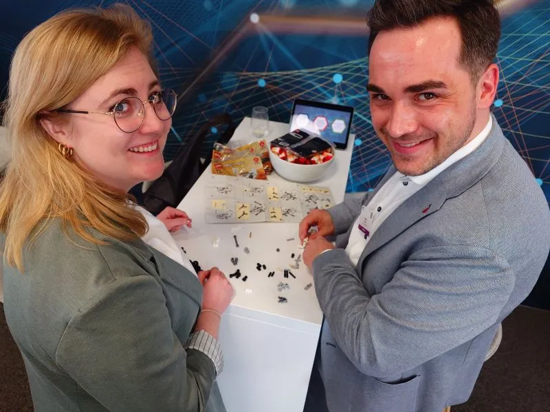 Kollegen bauen den LEGO-Marsrover am Messestand